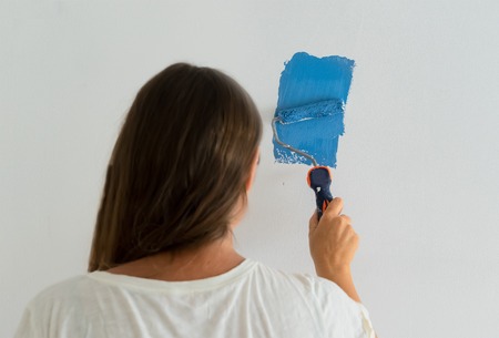 Woman painting wall of her house, do it yourself home renovation conceptの写真素材