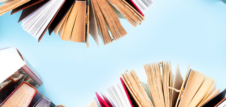 Pile of old books on blue background with copy spaceの写真素材