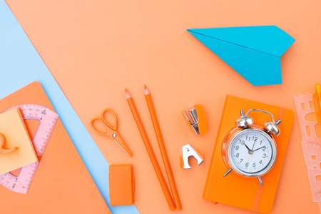 Back to school styled scene with school supplies and paper plane on orange backgroundの写真素材