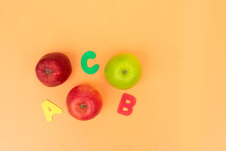 Back to school styled scene with apples and abc on orange backgroundの写真素材