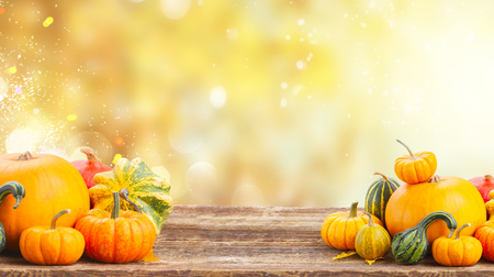 pile of orange pumpkins on wooden table over fall background bannerの写真素材