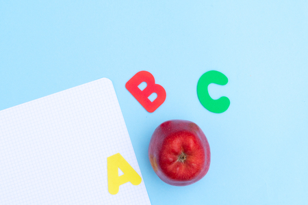 Back to school styled scene with abc letters and apple on blue backgroundの写真素材