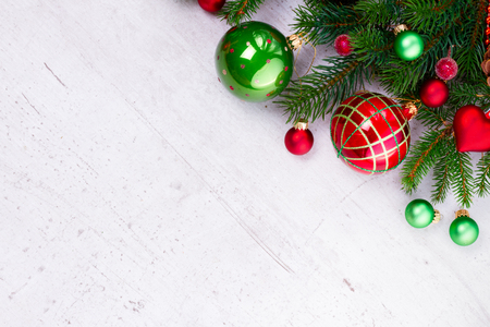 Evergreen twigs with red and green decorations, flat lay scene on white wooden backgroundの写真素材