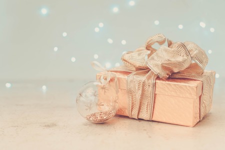 Christmas golden present box with bow and christmas ball retro tonedの写真素材