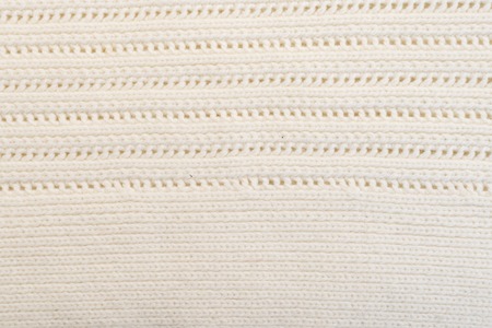 Texture of white woolen sweater close up background