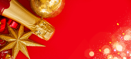 new year and christmas decorations with bottle of champagne, banner on red backgroundの写真素材