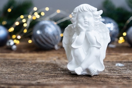 Christmas angel with silver decorations and lights in backgroundの写真素材