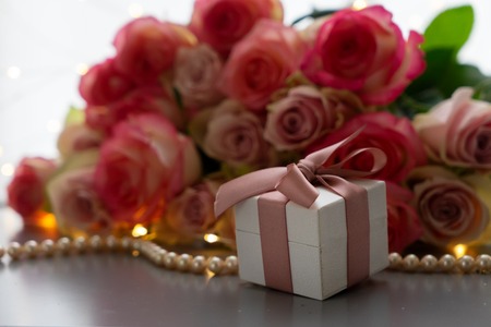 Rose fresh pink flowers bouquet with gift box on gray tableの写真素材