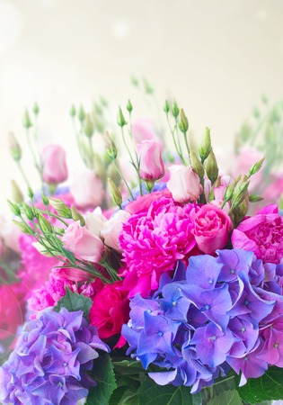 Bright pink peony, eustoma and blue hortensia flowers bouquet on gray bokeh backgroundの写真素材
