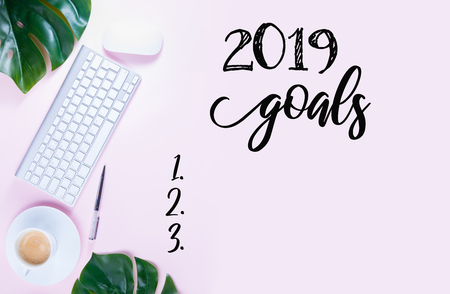 Top view 2019 goals list - white modern keyboard with coffee cup on pink background bannerの写真素材