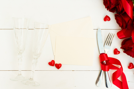 Served table for Valentines Dinner with red roses, top view with copy space on blank paperの写真素材
