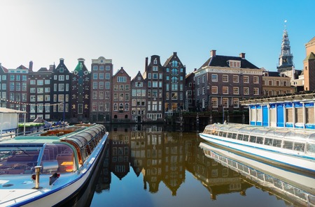 Amsterdam canal Damrak with typical dutch houses and moored boats, Holland, Netherlandsの写真素材