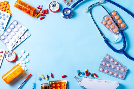 Healthcare concept - pills and medical instruments frame on blue  with copy spaceの写真素材