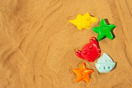 Toys in sand on beach, top view border with copy spaceの写真素材