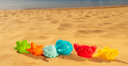 Toys in sand on beach by seasideの写真素材