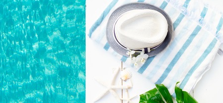 Summer flat lay top view scenery with hat, towel and flip flop sandals on white background bannerの写真素材