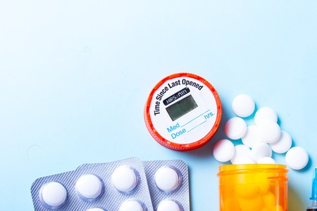 Healthcare concept - white pills medical border on blue with copy space