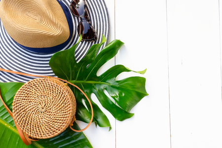Summer flat lay scenery with hat, bag, leaves on white background with copy spaceの写真素材