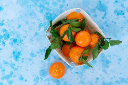 Tangerine friuts with leaves on blue backgroundの写真素材