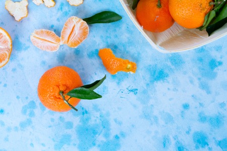 Tangerine friuts with leaves on blue background close upの写真素材