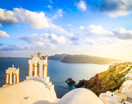 Traditional two white church belfries against volcano caldera, beautiful details of Santorini island, Greece, tonedの写真素材