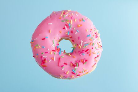one pink flying sweet doughnut with blue background