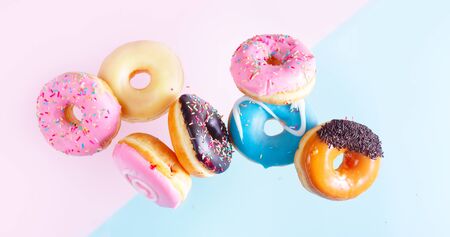 flying doughnuts on blue and pink background bannerの写真素材