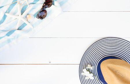 Summer flat lay scenery on white wooden background with summer towel and hat, copy spaceの写真素材