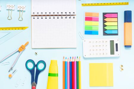Back to school concept with school supplies on blue  with copy space on empty notebook ruled pageの写真素材