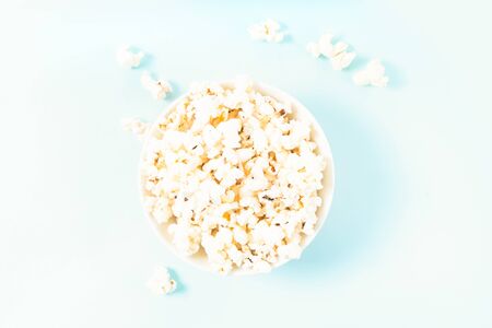 Bowl with popcorn over plain blue backgroundの写真素材