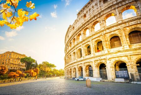 Ruins of antique Colosseum with street in sunrise lights, Rome Italy at fallの写真素材