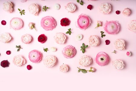 Flowers composition. Frame pattern made of roses and ranunculus flowers on pink background. Flat lay, top view borderの写真素材