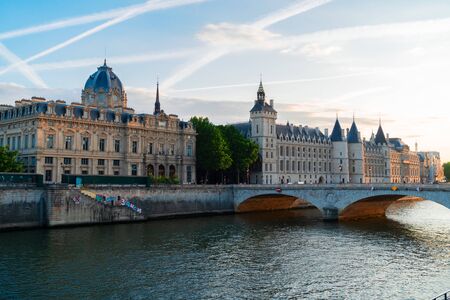 La Consiergerie - ex royal residence, Paris and Seine river with tour boat at sunny summer sunset, Paris, Franceの写真素材