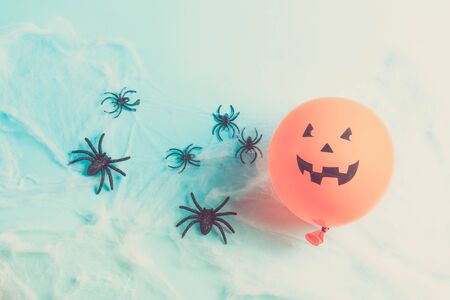 Halloween scene with scary balloon and spiders in web on blue, retro tonedの写真素材