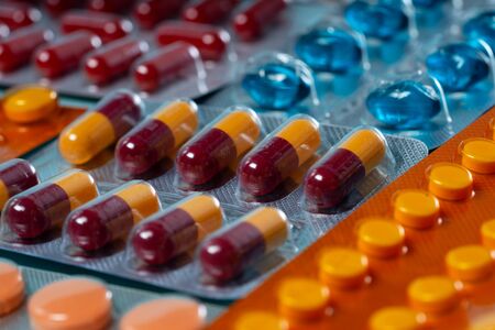 Pile of medical pills and capsules close up macro background. Pills in plastic package. Concept of...