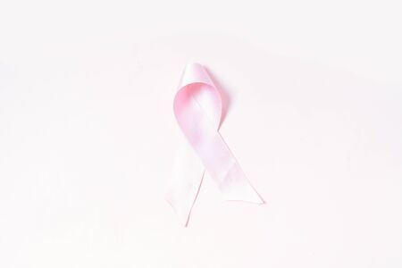 Pink ribbon, symbol of breast cancer awareness over pink backgroundの写真素材