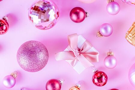 Christmas pink balls with gift box on pink background, tonedの写真素材