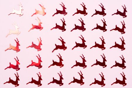 Christmas flat lay scene with red raindeer confetti pattern, top view over pinkの写真素材