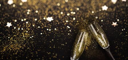Christmas amd Happy New Year Champagne over black background with gold glitter, web banner formatの写真素材