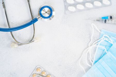 Healthcare concept - stethoscope and white pills on blue , corona viruses conceptの写真素材