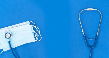 Healthcare concept - stethoscope and white masks on blue with copy space, corona viruses conceptの写真素材