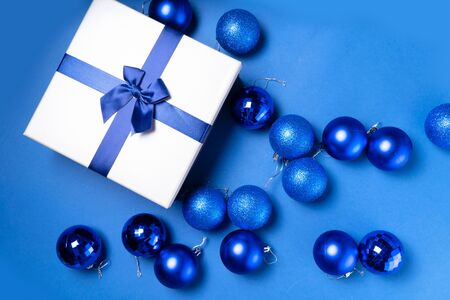 Christmas flat lay scene with gift box and glass balls close up in classic blue colorの写真素材