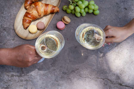 picnic with wine and croissants, couple cheers with glasses, top viewの写真素材