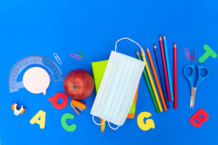 Back to school new normal concept with school supplies on classic blue background