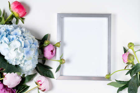 Beautiful fresh pink peony and hydrangea flowers on white table with copy space for your text over modern frame, top view and flat lay background with copy spaceの写真素材