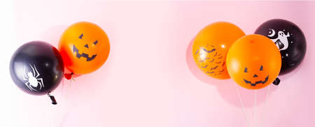 Halloween scene with orange and black balloons on pink backgroundの写真素材