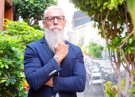 Senior confident man standing on a european streetの写真素材
