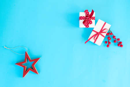 Christmas flat lay scene with stars and gift box on aqua blue background, top view