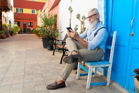 Senior hipster man is reading e-book, happiness, technology and elderly lifestyle people conceptの写真素材