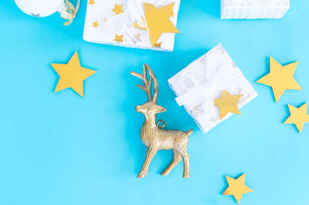 Christmas flat lay scene with golden stars and gift box on aqua blue background, top view